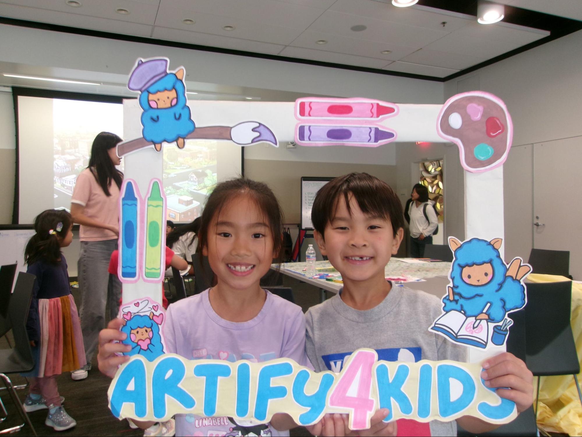 Two students pose with an Artify4Kids frame
