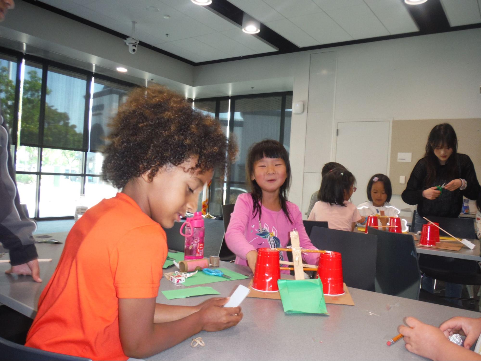 Students work on creating a rocket with cups and sticks