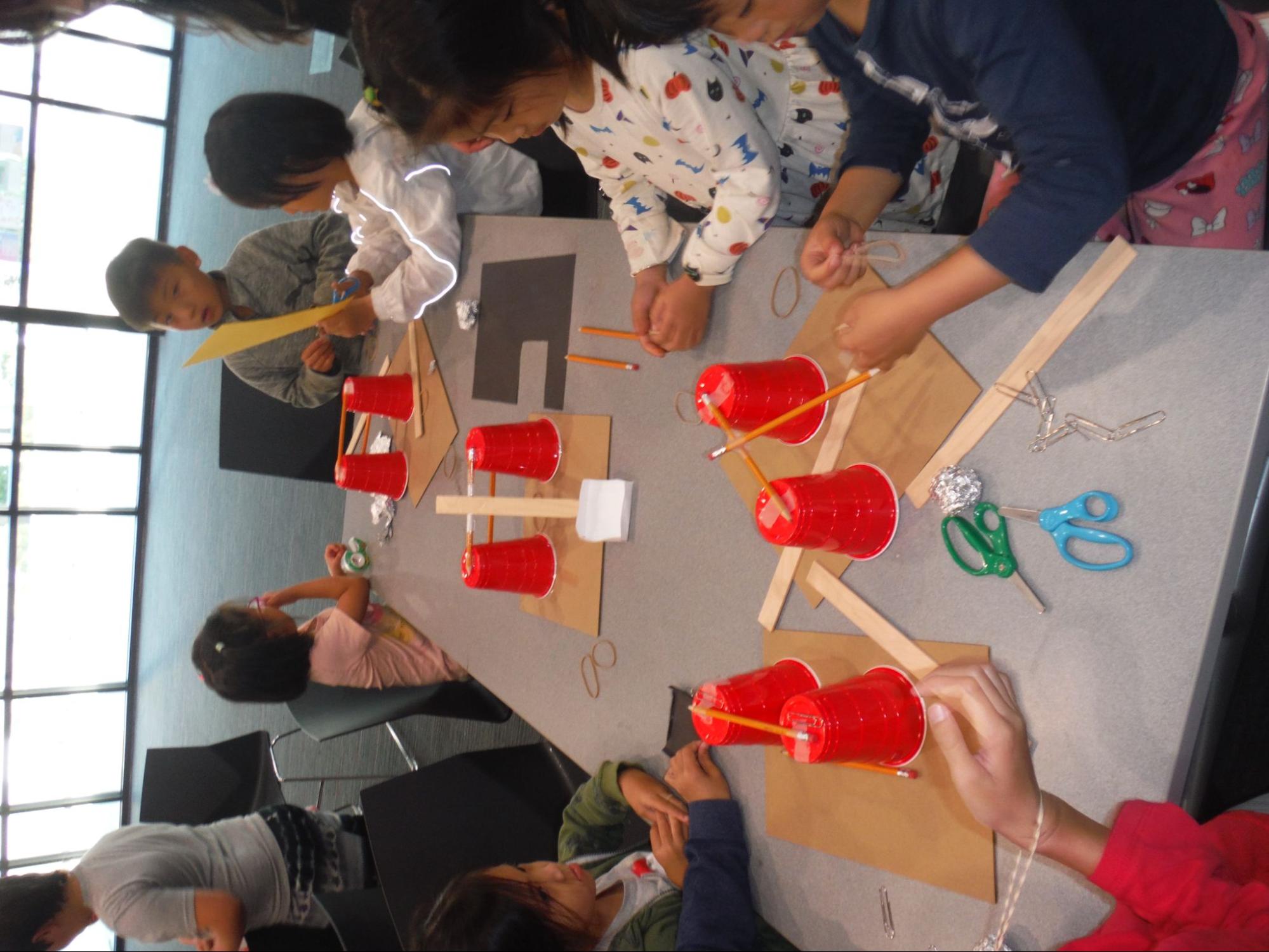 Students work on creating a rocket with cups and sticks